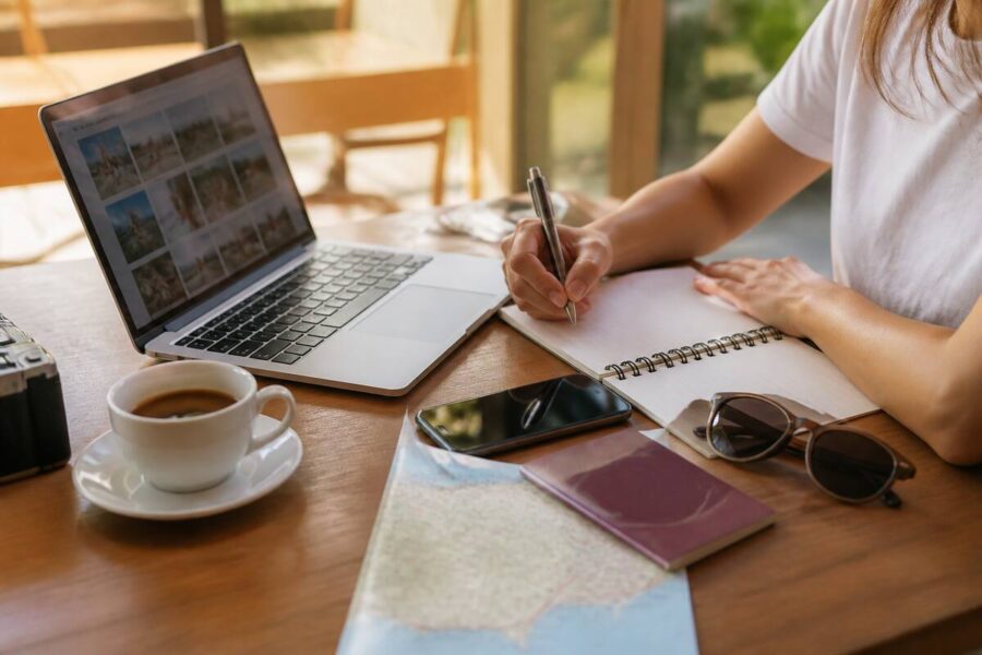 Vakantie plannen en reizen vergelijken aan tafel met laptop en reisnotities