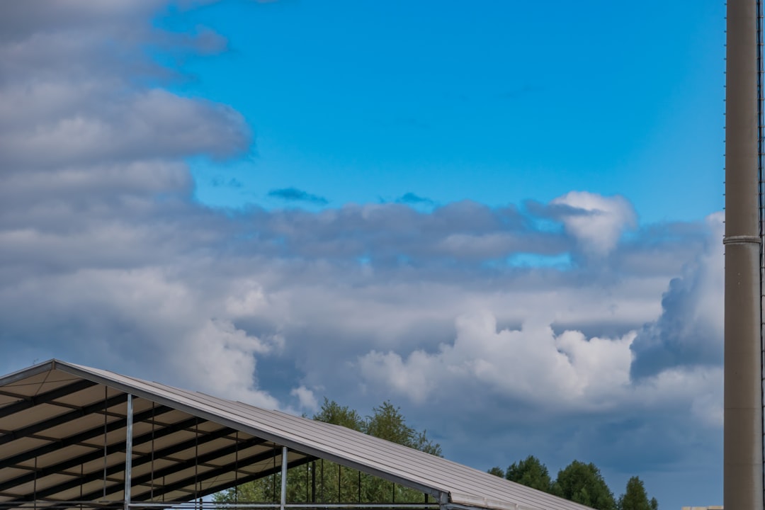 Partially covered structure under a cloudy blue sky